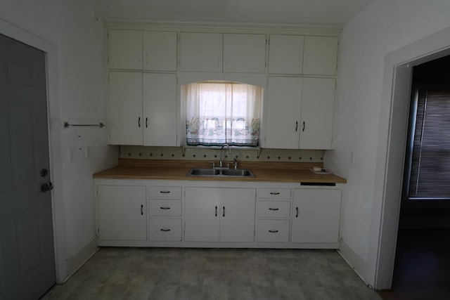 kitchen featuring white cabinets, backsplash, and sink