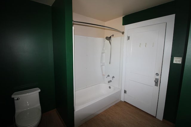 bathroom featuring bathing tub / shower combination, toilet, and hardwood / wood-style flooring