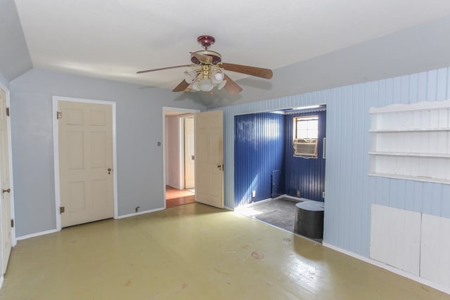 unfurnished bedroom featuring ceiling fan, wood walls, concrete flooring, and radiator