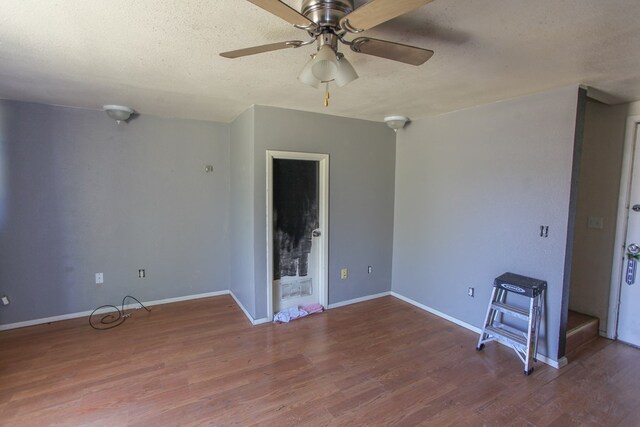 spare room with ceiling fan, a textured ceiling, and hardwood / wood-style flooring