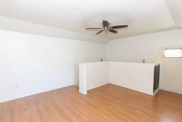 unfurnished room with lofted ceiling, ceiling fan, a textured ceiling, and light wood-type flooring