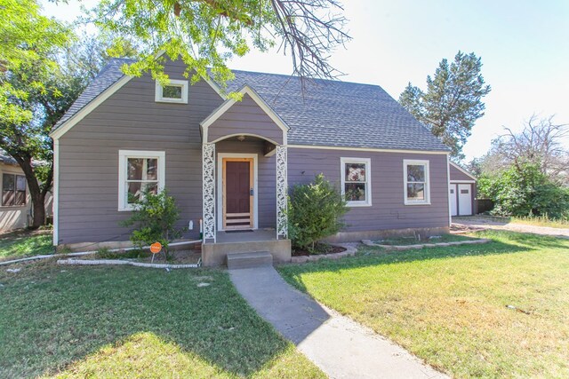 bungalow-style home featuring a garage and a front lawn