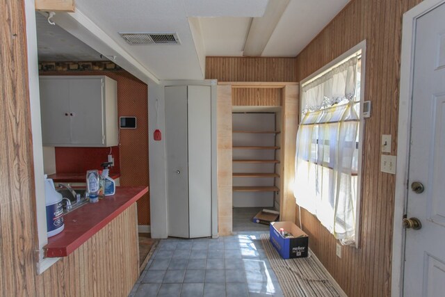 interior space featuring wood walls and light tile patterned floors