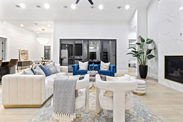 living area with light wood finished floors, a fireplace, and visible vents