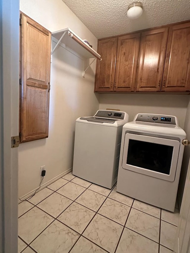 laundry area with cabinets, independent washer and dryer, and a textured ceiling