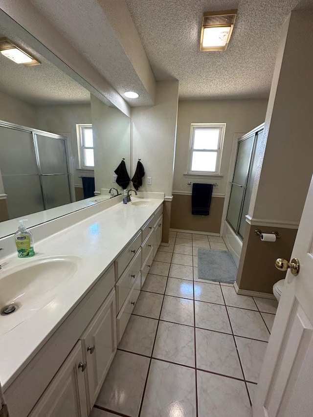 full bathroom featuring tile patterned floors, vanity, a textured ceiling, enclosed tub / shower combo, and toilet