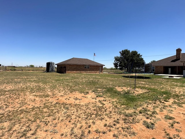 view of yard featuring a rural view and a trampoline