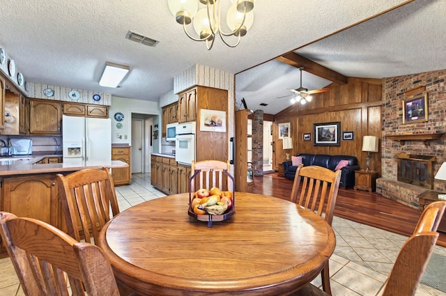 3013 Whittle Way, Midland, TX 79707 - dining space featuring a chandelier, wooden walls, a textured ceiling, light tile patterned floors, and ceiling fan