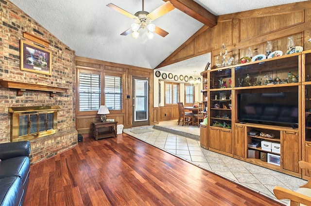 3013 Whittle Way, Midland, TX 79707 - living area with light wood finished floors, a ceiling fan, a fireplace, a textured ceiling, and wooden walls