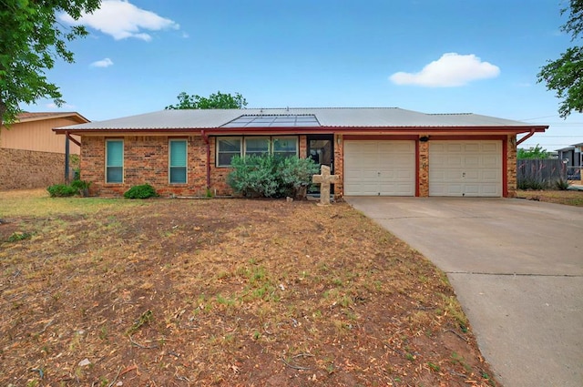 3013 Whittle Way, Midland, TX 79707 - ranch-style house featuring an attached garage, solar panels, concrete driveway, brick siding, and metal roof