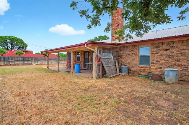 3013 Whittle Way, Midland, TX 79707 - rear view of property featuring a patio, a chimney, brick siding, and metal roof