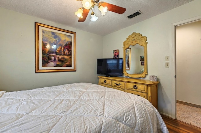 3013 Whittle Way, Midland, TX 79707 - bedroom featuring a textured ceiling, wood finished floors, and ceiling fan