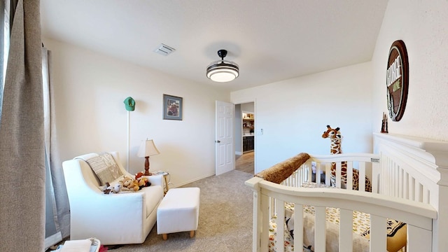 bedroom with light carpet and a crib