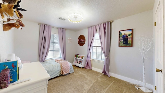 bedroom featuring light colored carpet and a textured ceiling