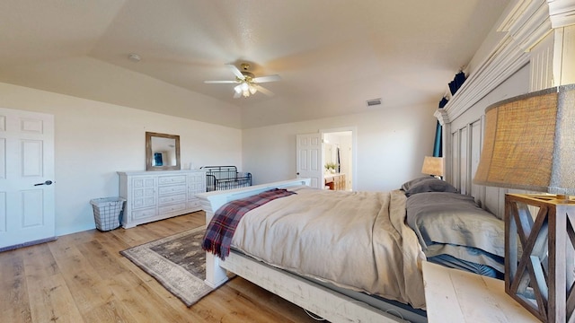 bedroom with ceiling fan, lofted ceiling, and light wood-type flooring