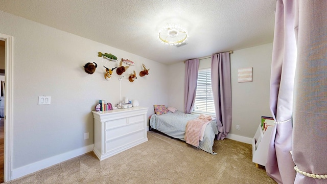 bedroom featuring light colored carpet and a textured ceiling