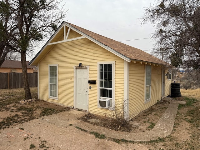 view of outbuilding featuring cooling unit and fence