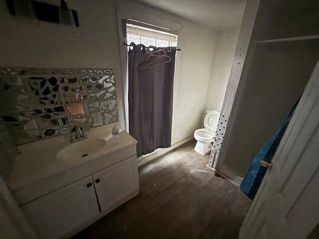 full bath featuring toilet, vanity, a shower with shower curtain, and wood finished floors