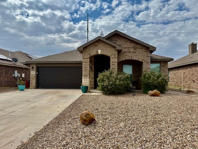 1406 Wrangler Ln, Midland, TX 79705 - french country home with an attached garage, driveway, and brick siding