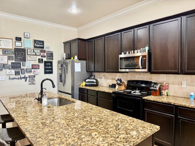 1406 Wrangler Ln, Midland, TX 79705 - kitchen featuring stainless steel appliances, a breakfast bar, an island with sink, light stone countertops, and backsplash