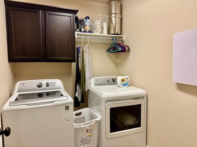 1406 Wrangler Ln, Midland, TX 79705 - laundry room featuring washing machine and clothes dryer and cabinet space