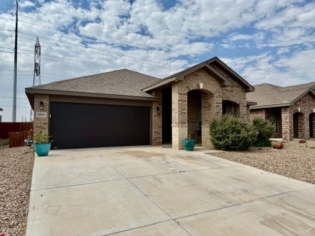 1406 Wrangler Ln, Midland, TX 79705 - view of front facade featuring brick siding, a garage, concrete driveway, and roof with shingles