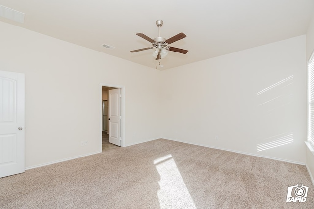 empty room featuring light carpet, ceiling fan, baseboards, and visible vents