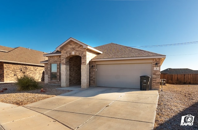 ranch-style home featuring driveway, an attached garage, brick siding, fence, and a shingled roof