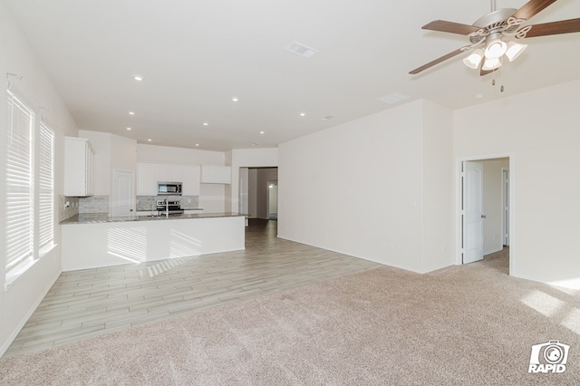 unfurnished living room with light carpet, recessed lighting, visible vents, and a ceiling fan