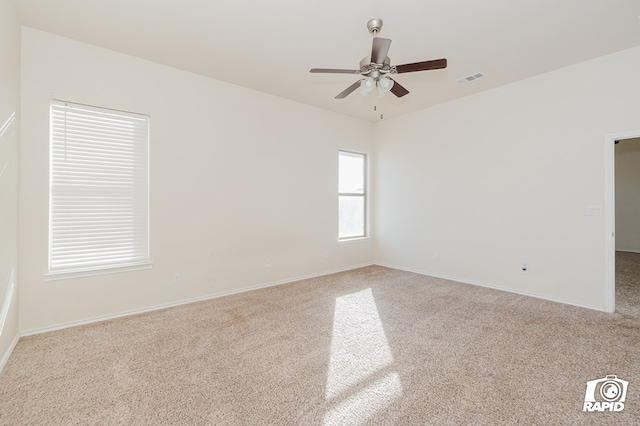 carpeted empty room with ceiling fan, baseboards, and visible vents