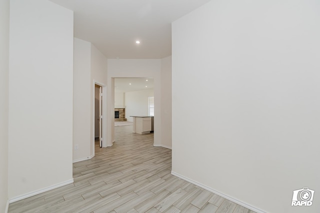 corridor featuring recessed lighting, light wood-type flooring, and baseboards
