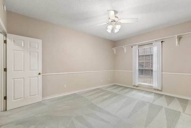 unfurnished room with a ceiling fan, a textured ceiling, carpet floors, and baseboards