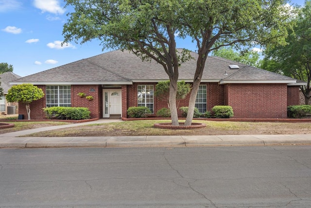 single story home with brick siding and a shingled roof