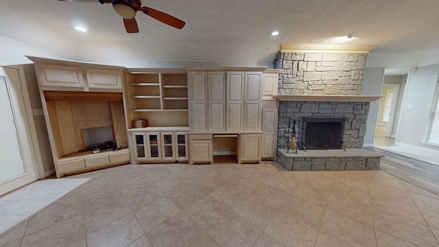 3608 Apollo Ct, Midland, TX 79707 - unfurnished living room featuring a fireplace, a textured ceiling, a ceiling fan, light tile patterned floors, and baseboards