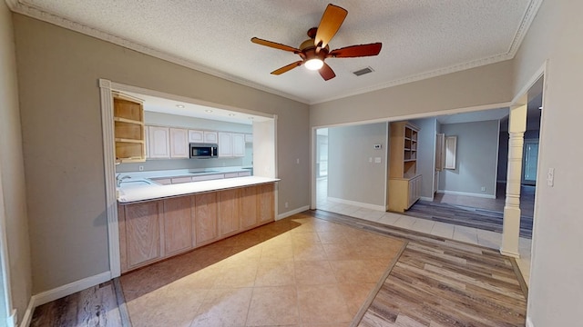 3608 Apollo Ct, Midland, TX 79707 - kitchen featuring stainless steel microwave, crown molding, a textured ceiling, a ceiling fan, and light tile patterned floors