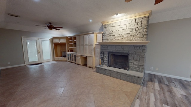 3608 Apollo Ct, Midland, TX 79707 - unfurnished living room with a ceiling fan, a fireplace, baseboards, a textured ceiling, and light tile patterned flooring