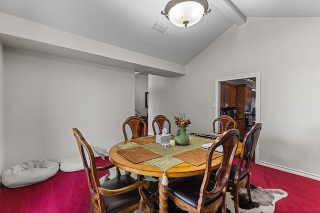 dining room featuring vaulted ceiling with beams and carpet