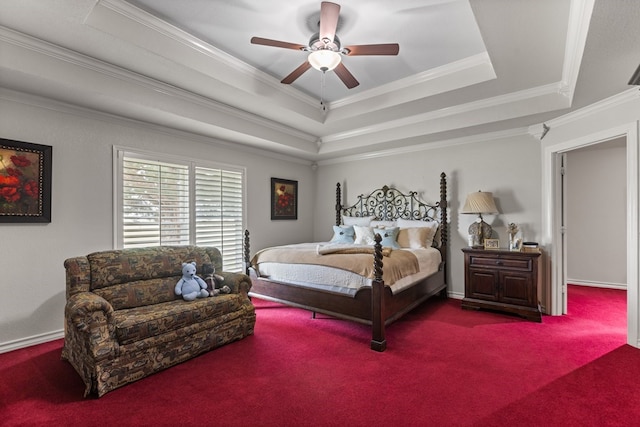 bedroom with crown molding, a tray ceiling, ceiling fan, and carpet flooring