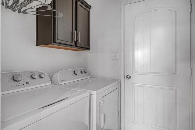 clothes washing area with cabinet space and washing machine and clothes dryer