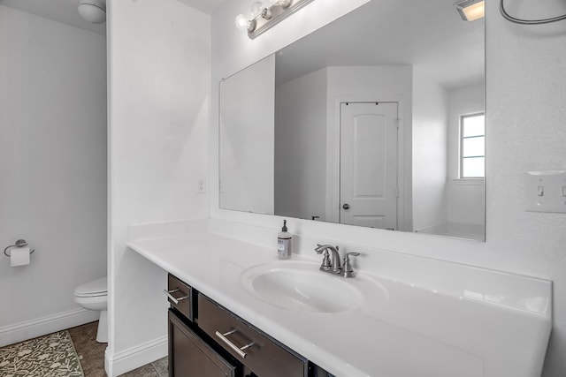 bathroom with toilet, baseboards, vanity, and tile patterned floors
