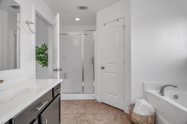 bathroom featuring a stall shower, vanity, a bath, and tile patterned flooring