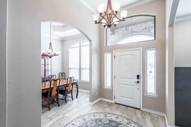 entryway featuring crown molding, baseboards, and an inviting chandelier