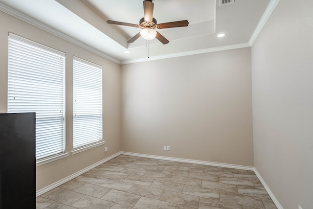 spare room featuring a healthy amount of sunlight, baseboards, a raised ceiling, and a ceiling fan