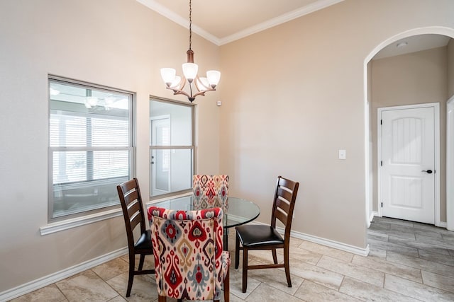 dining space with arched walkways, crown molding, baseboards, and an inviting chandelier