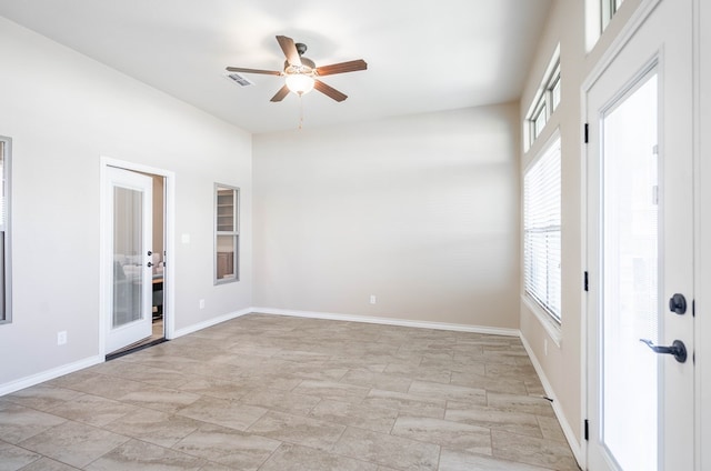 empty room featuring visible vents, ceiling fan, and baseboards