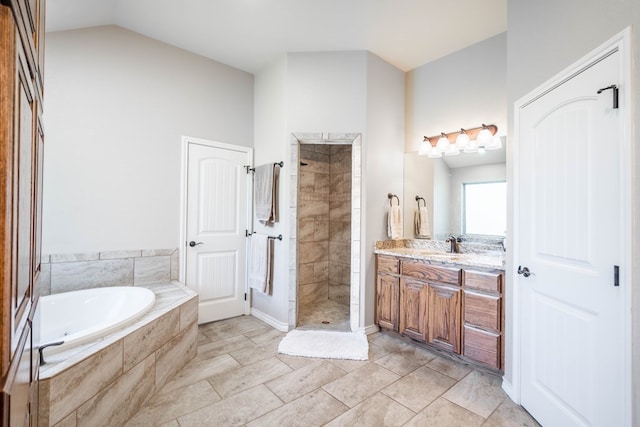 bathroom featuring lofted ceiling, a garden tub, a shower stall, and vanity