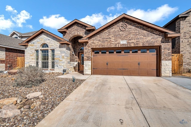 french country style house featuring a garage, brick siding, and driveway