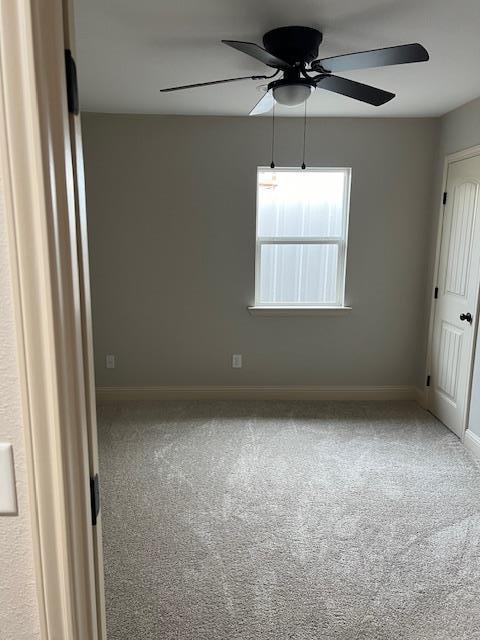 carpeted empty room featuring ceiling fan