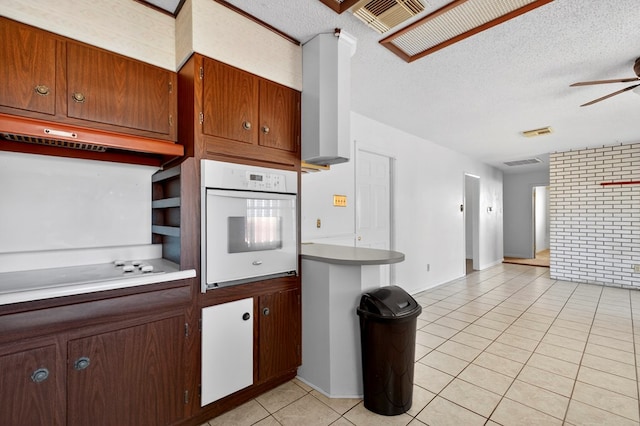 4709 Shadylane Dr, Midland, TX 79703 - kitchen featuring white oven, stovetop, light tile patterned floors, a ceiling fan, and a textured ceiling
