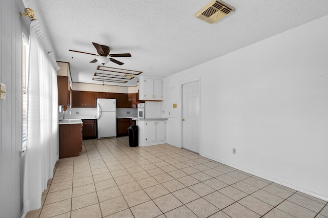 4709 Shadylane Dr, Midland, TX 79703 - kitchen with white appliances, light countertops, ceiling fan, a textured ceiling, and a peninsula